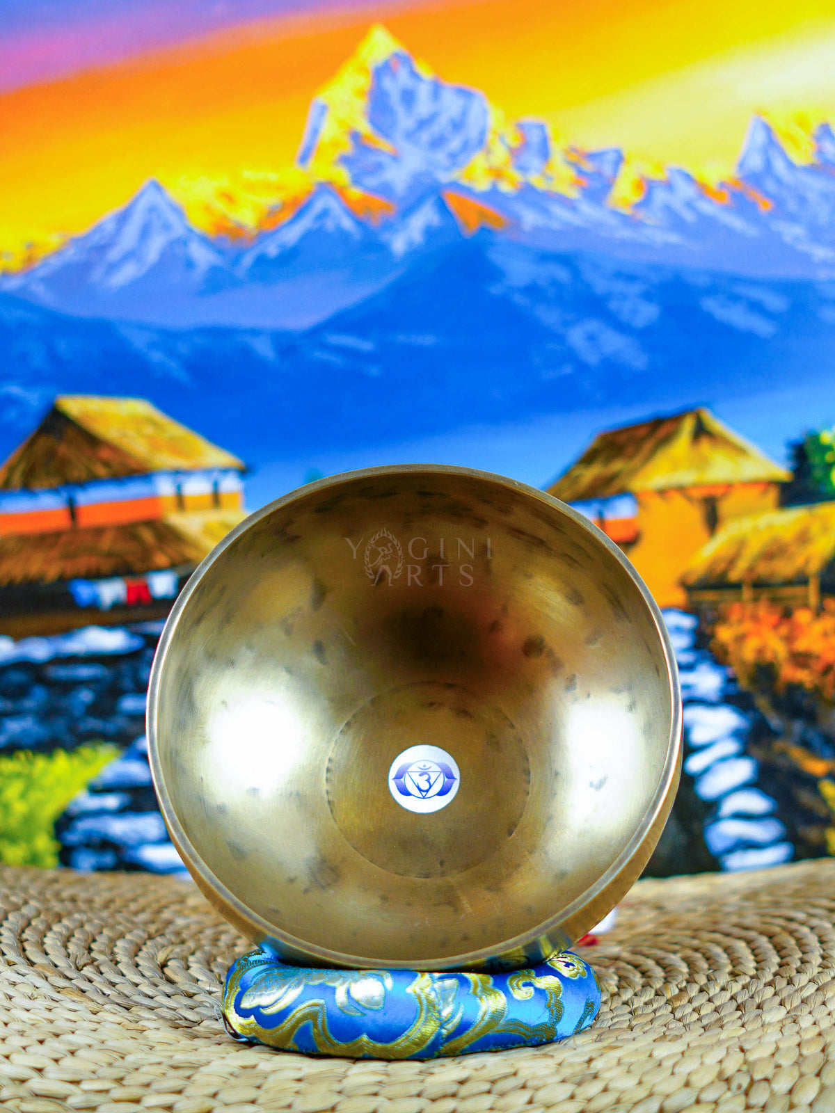 Himalayan singing bowl set displayed with wooden mallets and decorative cushions for meditation and sound practice.