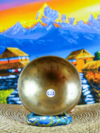 Himalayan singing bowl set displayed with wooden mallets and decorative cushions for meditation and sound practice.