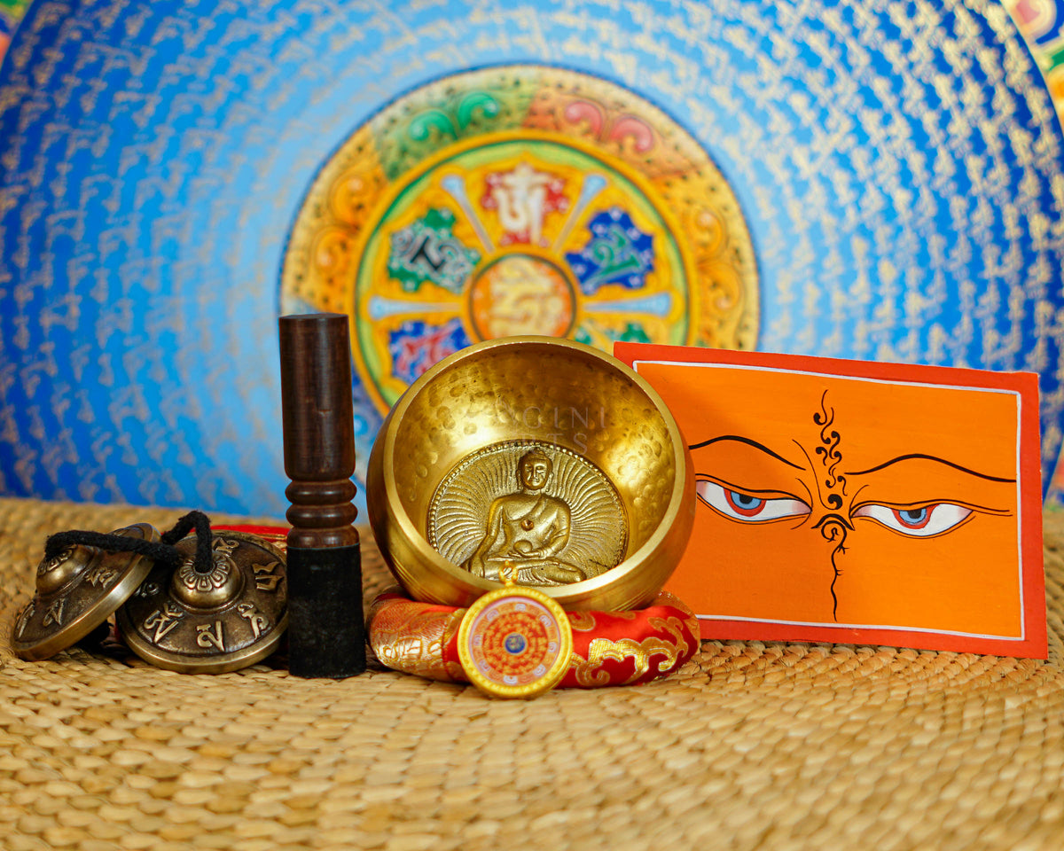 Buddha design singing bowl with tingsha, wooden striker, cushion and Buddhist devotional accessories