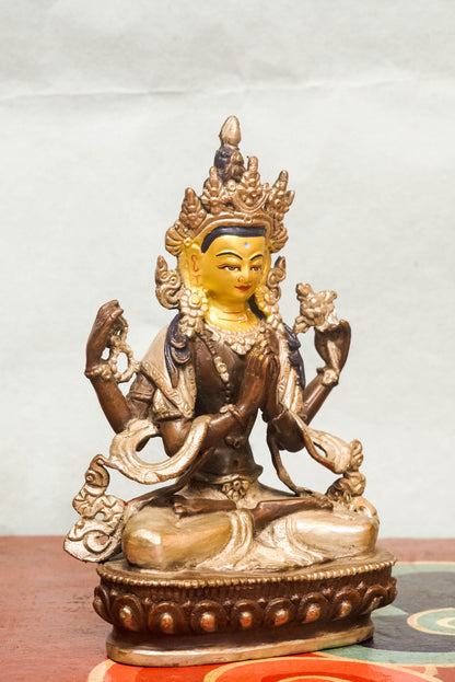 Chenrezig statue features a gold-painted face symbolizing wisdom and a silver-painted leg representing purity. Depicting the four-armed Bodhisattva of Compassion, it holds a lotus, prayer beads, and a wish-fulfilling jewel. It is meaningful symbol of compassion and purity.