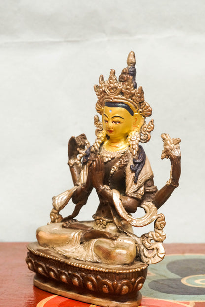 Chenrezig statue features a gold-painted face symbolizing wisdom and a silver-painted leg representing purity. Depicting the four-armed Bodhisattva of Compassion, it holds a lotus, prayer beads, and a wish-fulfilling jewel. It is meaningful symbol of compassion and purity.
