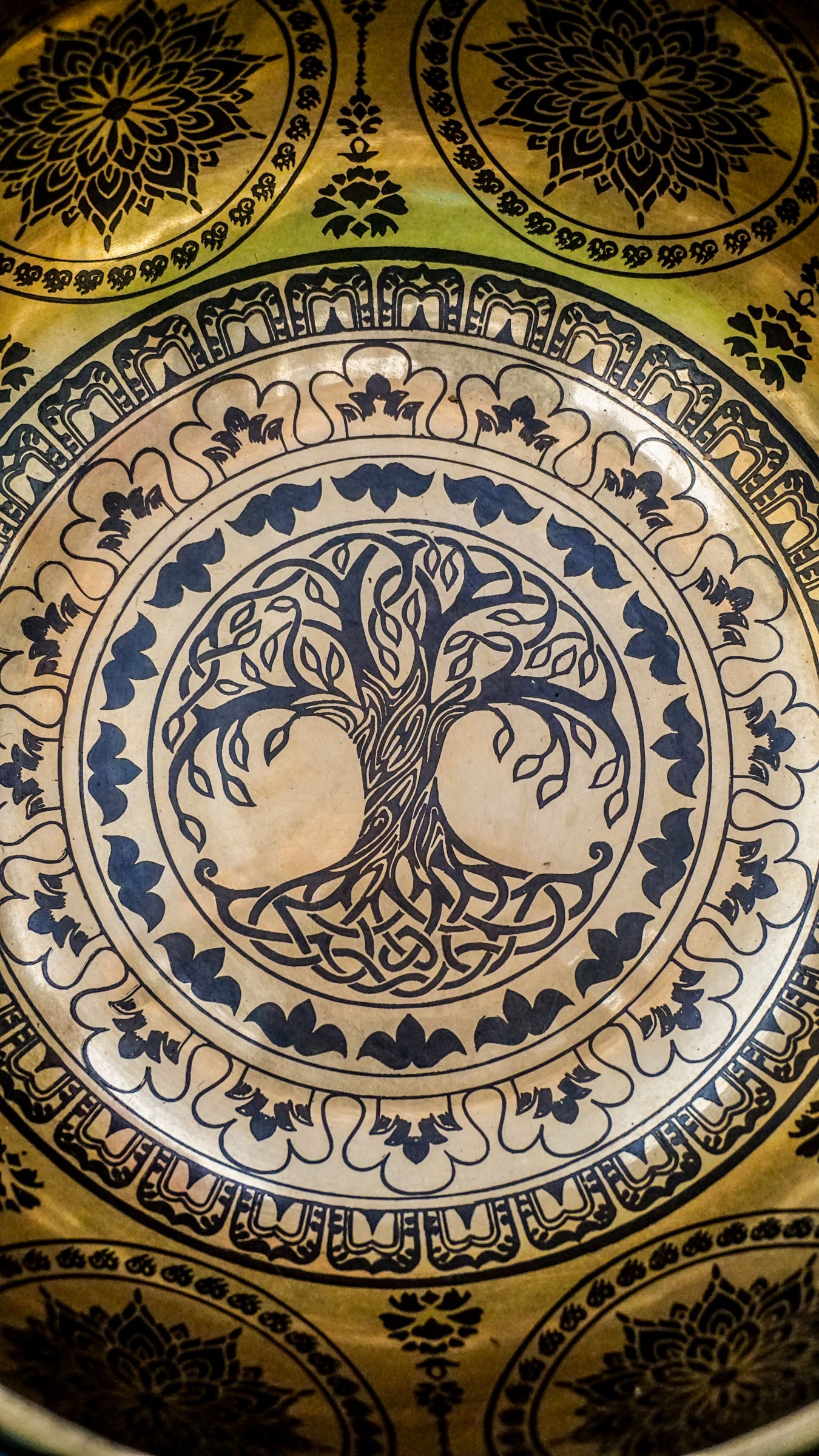 Handcrafted Tree of Life singing bowl featuring a central tree design, surrounding motif and floral patterns inside, and repeated Tree of Life engravings on the outside; includes wooden mallet and silk cushion, ideal for meditation and grounding.