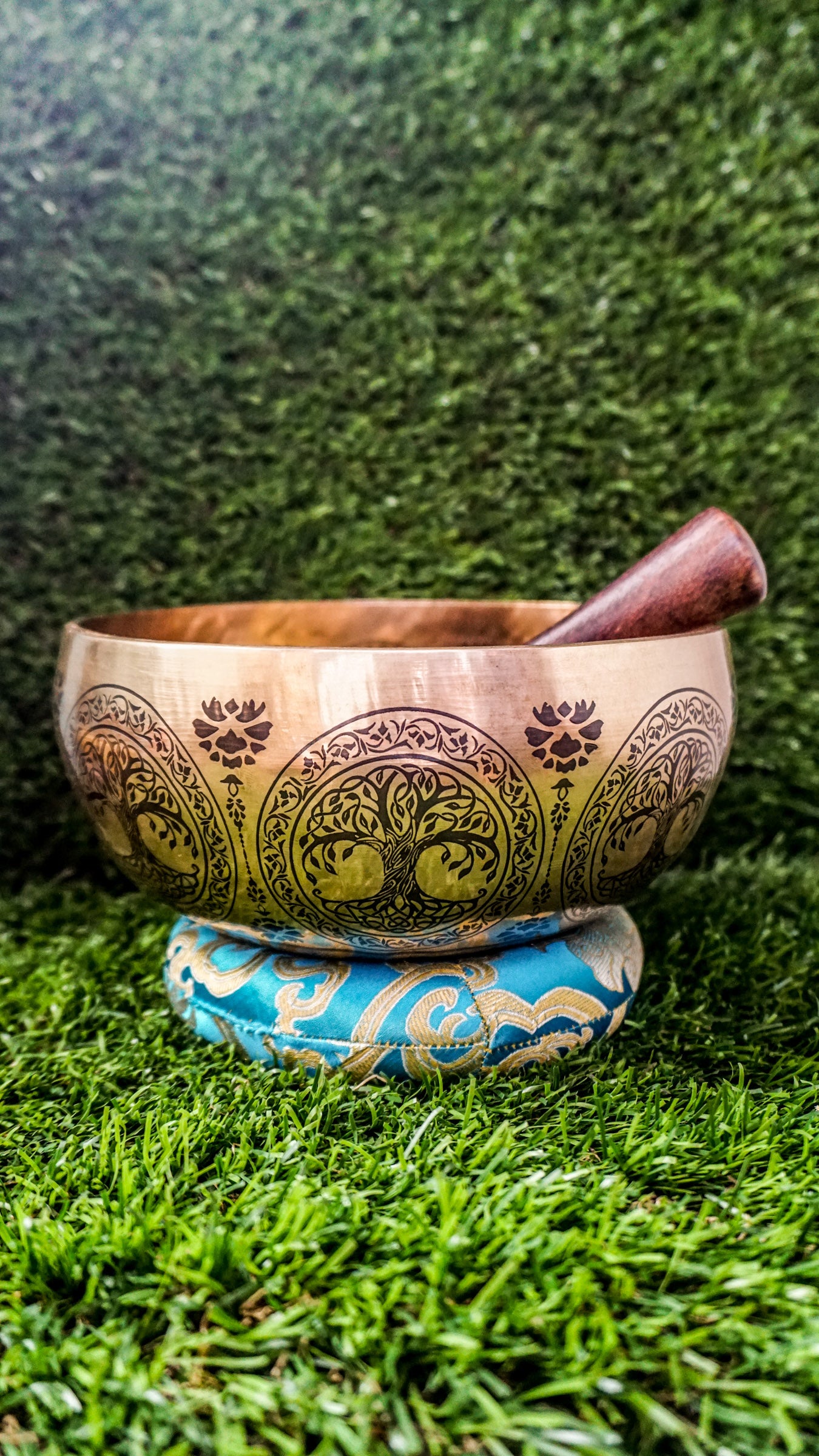 Handcrafted Tree of Life singing bowl featuring a central tree design, surrounding motif and floral patterns inside, and repeated Tree of Life engravings on the outside; includes wooden mallet and silk cushion, ideal for meditation and grounding.