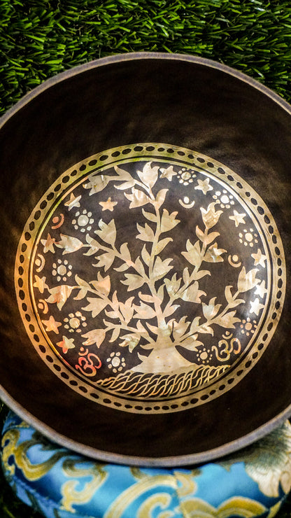 The Tree of Life Singing Bowl offers grounding and calm through sound and symbolism. At its center is the Tree of Life, representing growth and connection. Delicate floral patterns surround the design inside and out, adding natural beauty. Its warm, steady tone encourages balance, reflection, and inner peace.