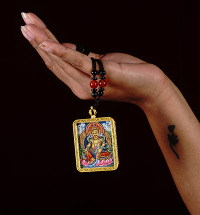 Hand-painted Zambala miniature Thangka pendant inside gold-accented copper Ghau locket with black and red beaded cord.