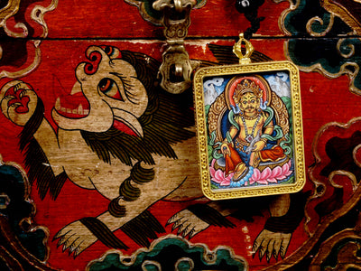 Hand-painted Zambala miniature Thangka pendant inside gold-accented copper Ghau locket with black and red beaded cord.