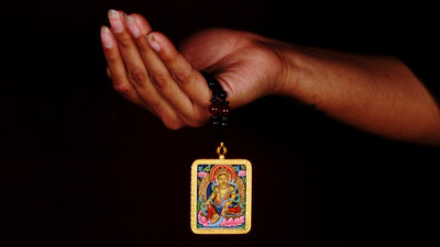 Hand-painted Yellow Zambala miniature Thangka pendant in gold-accented copper Ghau locket with black beaded cord.