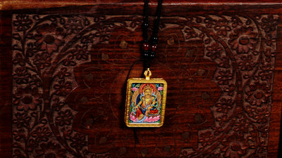 Hand-painted Yellow Zambala miniature Thangka pendant in gold-accented copper Ghau locket with black beaded cord.