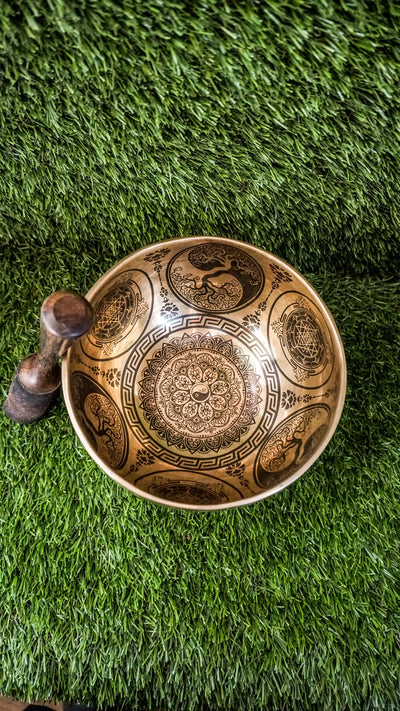 Handcrafted Yin Yang singing bowl with engraved Yin Yang symbol inside and flowing linework outside; includes wooden mallet and silk cushion, producing calming tones for balance, harmony, and meditation.