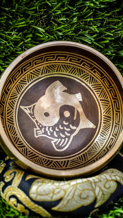 Yin Yang Fish Singing Bowl featuring two koi fish symbolizing balance and harmony. Wrapped in Om Mani Padme Hum mantra, it produces calming tones ideal for meditation and grounding.