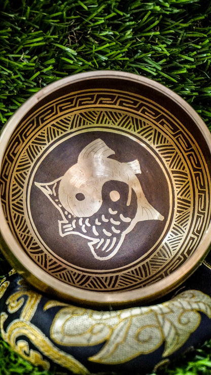 The Yin Yang Fish Singing Bowl celebrates balance and flow. Two koi fish swim in a yin yang pattern at its center, symbolizing harmony and life’s cycles. The Om Mani Padme Hum mantra wraps the outside, adding calming spiritual energy. Its clear, soothing tones help quiet the mind and bring focus. Perfect for meditation or creating peace, this bowl supports grounding and balance throughout your day