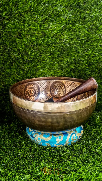 This chakra singing bowl features a central seven-chakra figure surrounded by gentle symbols. Its clear, calming tone supports alignment, healing, and mindful grounding.
