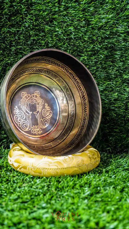 The Two Fish and Lotus Singing Bowl symbolizes harmony and growth. Inside, two fish face each other with a lotus beneath. The outside shows the Om Mani Padme Hum mantra in Tibetan. Its clear, calming tones support meditation and relaxation. Perfect for creating peace and balance in any space.