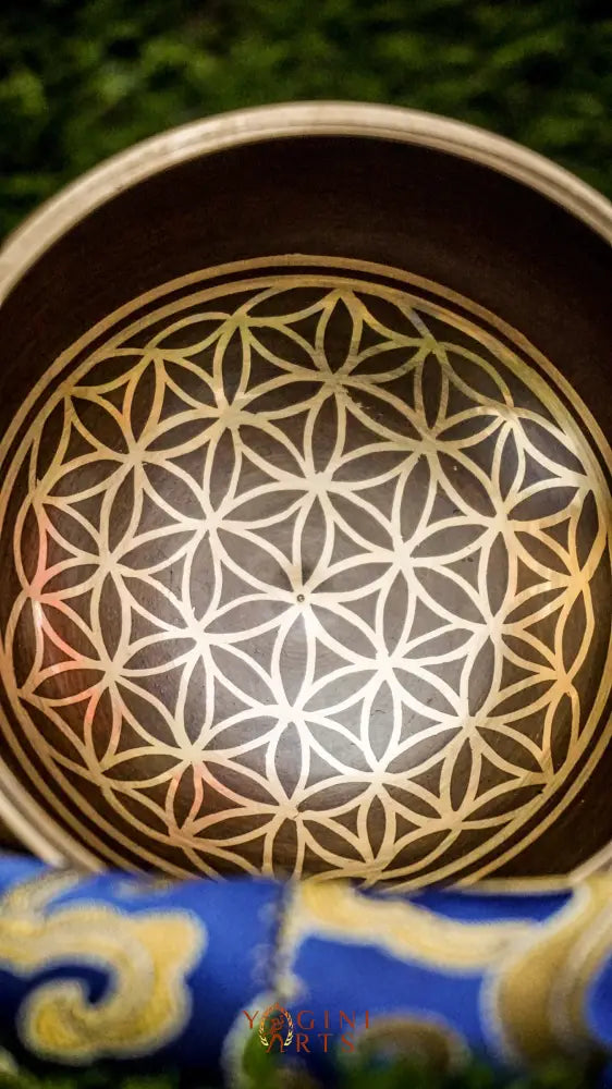 Invite harmony, balance, and positive energy with our handcrafted Flower of Life Singing Bowl. Featuring the sacred Flower of Life symbol inside and intricate geometric patterns outside, it represents unity and the cycle of life. Handmade by skilled artisans, this bowl produces clear, calming tones that support meditation, relaxation, and emotional balance. Includes a wooden mallet and silk cushion. Perfect for any meditation space or spiritual journey.