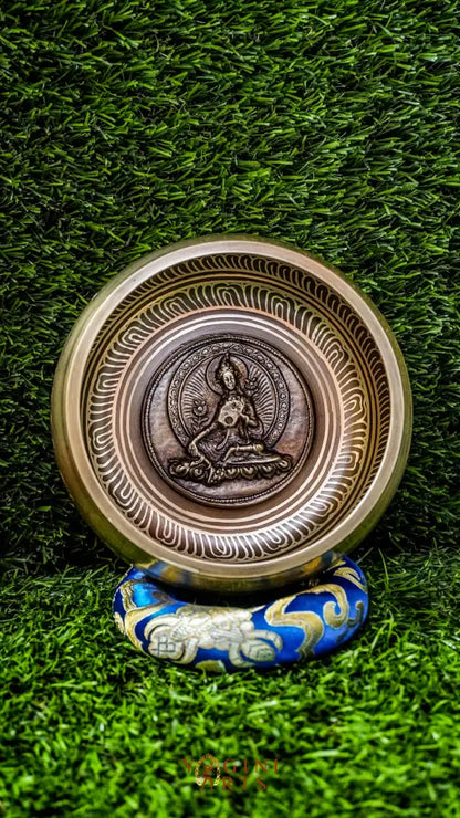 A beautifully carved singing bowl featuring the Green Tara deity at its center, surrounded by Om Mani Padme Hum inscriptions. This bowl produces a rich, resonant tone that supports meditation and spiritual practice. Green Tara symbolizes compassion, swift healing, and protection. Ideal for deepening your meditation practice, enhancing your altar space, or creating moments of inner peace and clarity.