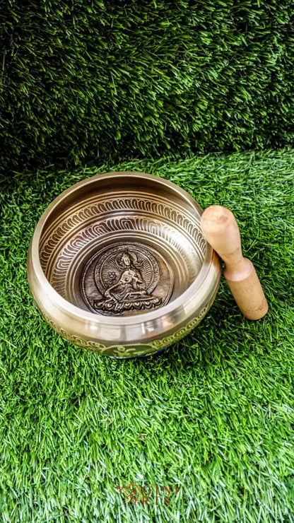A beautifully carved singing bowl featuring the Green Tara deity at its center, surrounded by Om Mani Padme Hum inscriptions. This bowl produces a rich, resonant tone that supports meditation and spiritual practice. Green Tara symbolizes compassion, swift healing, and protection. Ideal for deepening your meditation practice, enhancing your altar space, or creating moments of inner peace and clarity.