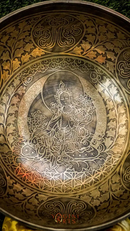 Invite compassion and healing into your space with our handcrafted Green Tara Singing Bowl. Featuring a detailed image of Green Tara inside, it symbolizes protection, care, and swift aid. The exterior is engraved with sacred patterns that amplify her blessings. Handmade by skilled artisans, this bowl produces clear, soothing tones that promote peace and focus. Includes a wooden mallet and silk cushion for easy use and care.