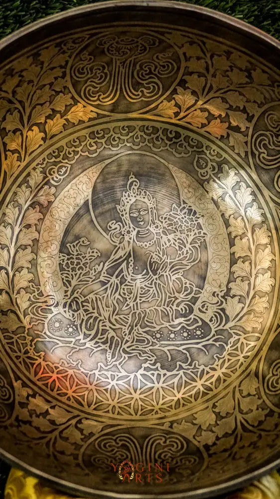 Invite compassion and healing into your space with our handcrafted Green Tara Singing Bowl. Featuring a detailed image of Green Tara inside, it symbolizes protection, care, and swift aid. The exterior is engraved with sacred patterns that amplify her blessings. Handmade by skilled artisans, this bowl produces clear, soothing tones that promote peace and focus. Includes a wooden mallet and silk cushion for easy use and care.