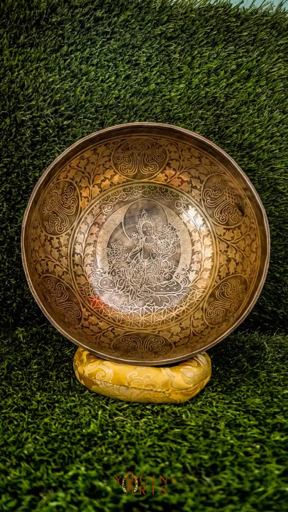 Invite compassion and healing into your space with our handcrafted Green Tara Singing Bowl. Featuring a detailed image of Green Tara inside, it symbolizes protection, care, and swift aid. The exterior is engraved with sacred patterns that amplify her blessings. Handmade by skilled artisans, this bowl produces clear, soothing tones that promote peace and focus. Includes a wooden mallet and silk cushion for easy use and care.