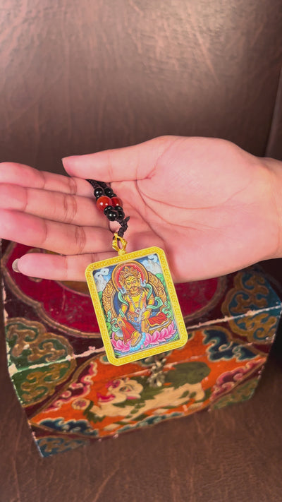 Hand-painted Zambala miniature Thangka pendant inside gold-accented copper Ghau locket with black and red beaded cord.