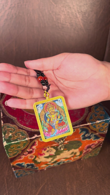 Hand-painted Zambala miniature Thangka pendant inside gold-accented copper Ghau locket with black and red beaded cord.