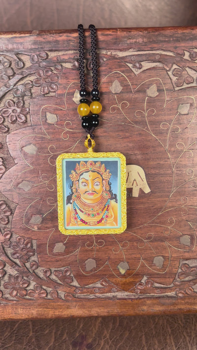 Hand-painted Zambala portrait miniature Thangka pendant in gold-accented copper Ghau locket with black beaded cord.