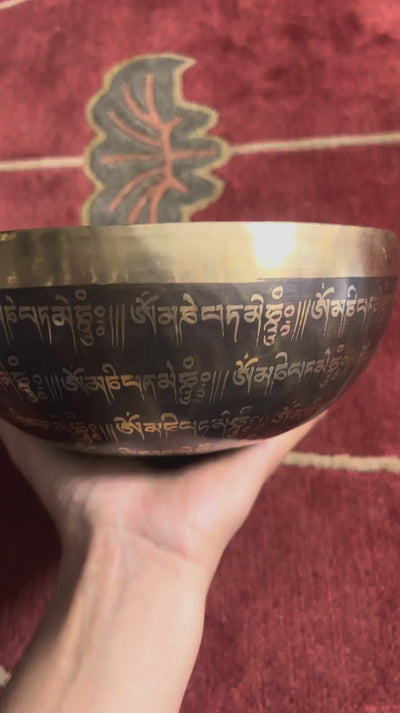 Detail of the sacred Om symbol and circular mantra engravings inside a traditional Himalayan inspired singing bowl.