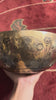Universe singing bowl shown upright with a wooden mallet and pink cushion, featuring detailed celestial engravings inside.