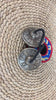Close up of Tibetan Buddhist tingsha cymbals showing raised mantra symbols and detailed circular borders.