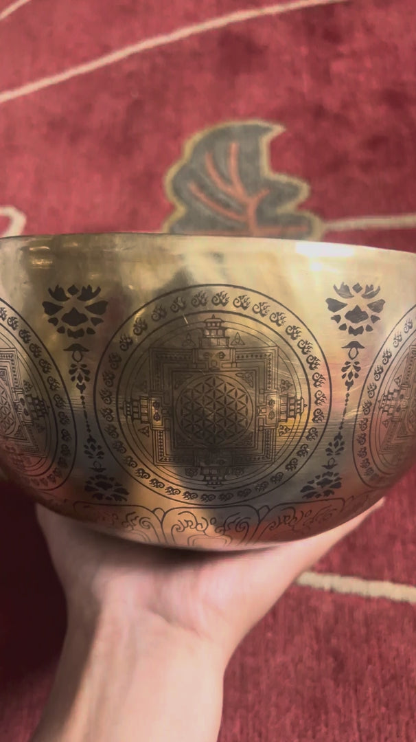 Load video: Thousand Armed Avalokiteshvara singing bowl shown upright with a wooden mallet and blue cushion, displaying the intricate Buddhist engraving.