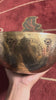 Thousand Armed Avalokiteshvara singing bowl shown upright with a wooden mallet and blue cushion, displaying the intricate Buddhist engraving.
