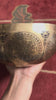 Mahakala engraved singing bowl displayed upright on a blue cushion with a wooden mallet, highlighting the detailed interior artwork.