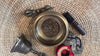 Handcrafted bronze Buddha singing bowl displayed with Buddhist ritual accessories
