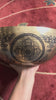 Interior view of Chengresi singing bowl showing the four armed Bodhisattva, lotus throne, Tibetan inscriptions, and decorative motifs
