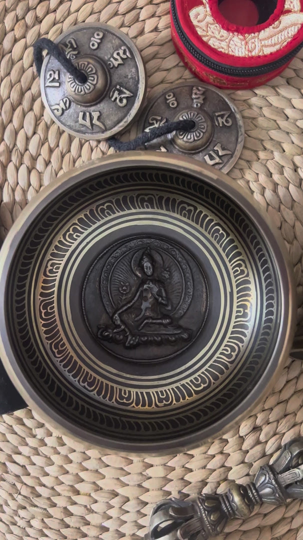 Load video: Green Tara bronze singing bowl displayed with traditional Buddhist bell and vajra