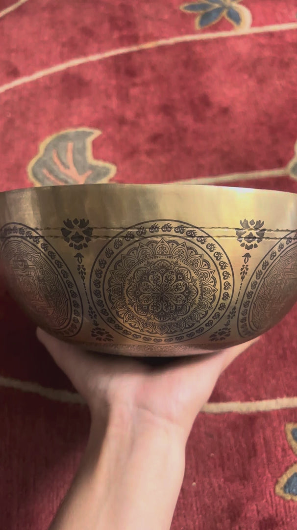 Kalchakra Yogini Singing Bowl displayed upright with a wooden mallet and blue cushion, showing the central mandala design.