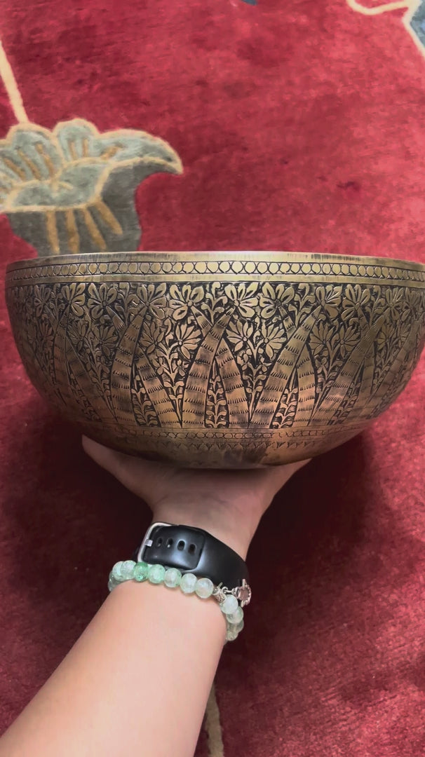 Semi antique floral engraved Tibetan singing bowl handcrafted in Nepal with detailed botanical patterns and antique bronze finish
