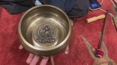 A beautifully carved singing bowl featuring the Green Tara deity at its center, surrounded by Om Mani Padme Hum inscriptions. This bowl produces a rich, resonant tone that supports meditation and spiritual practice. Green Tara symbolizes compassion, swift healing, and protection. Ideal for deepening your meditation practice, enhancing your altar space, or creating moments of inner peace and clarity.