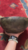 Semi antique Tibetan singing bowl handmade in Nepal with aged bronze finish on a traditional blue cushion