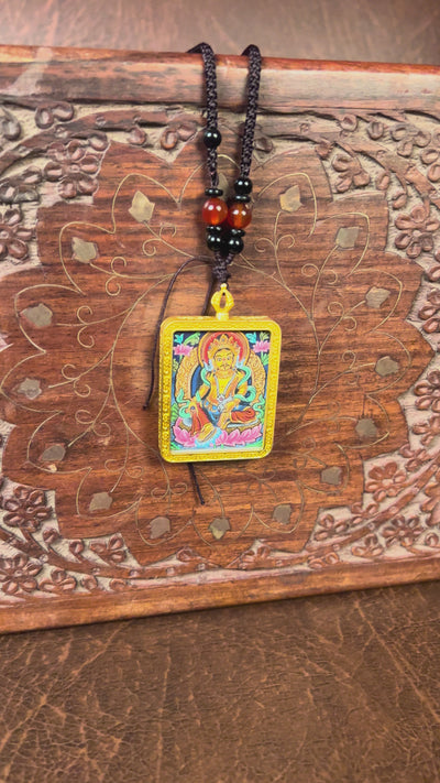 Hand-painted Yellow Zambala miniature Thangka pendant in gold-accented copper Ghau locket with black beaded cord.
