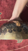 Green Tara singing bowl displaying engraved auspicious knots and traditional decorative motifs on the exterior