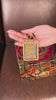 Hand-painted Zambala miniature Thangka pendant in gold-accented copper Ghau locket displayed hanging from black beaded cord.
