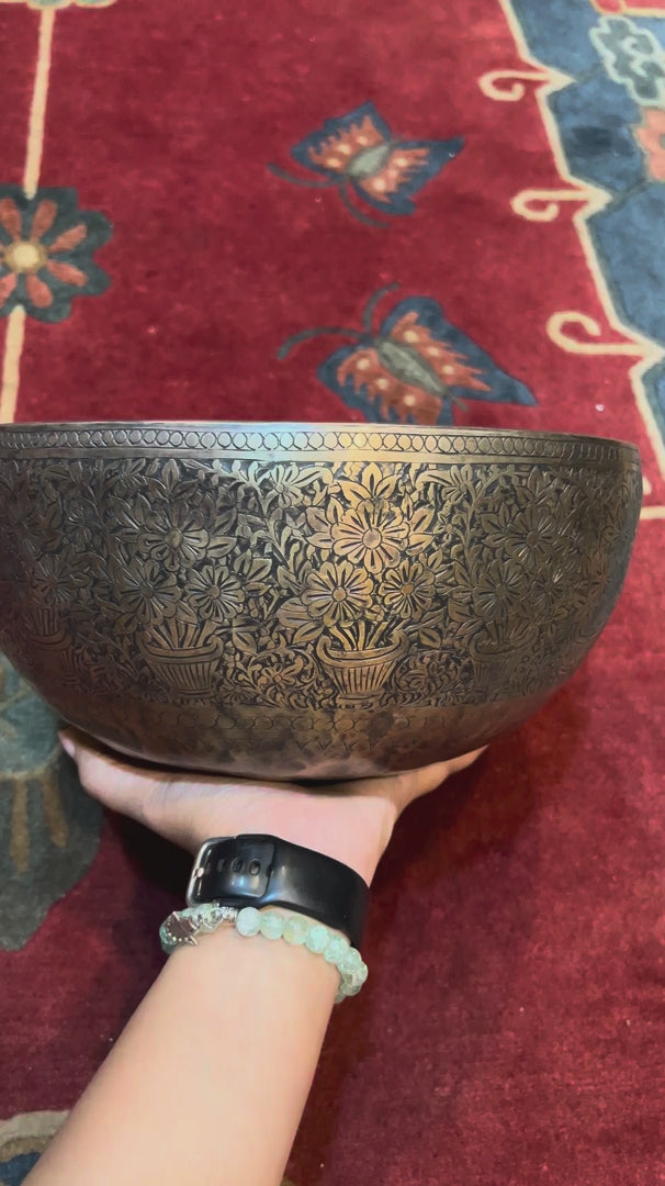 Semi antique handmade singing bowl with intricate flower vase engraving and floral patterns on aged bronze