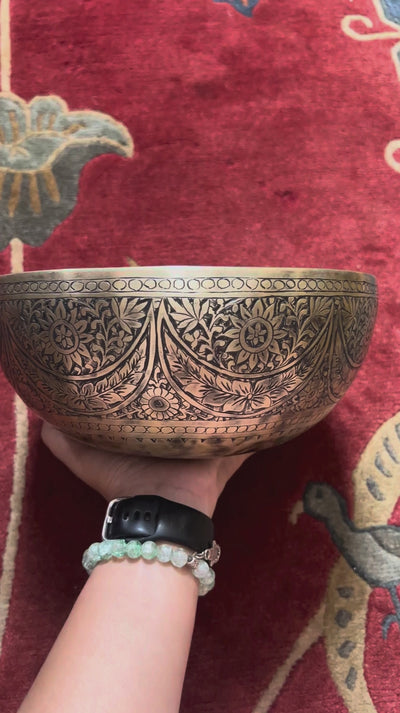 Semi antique singing bowl with intricate floral engraved panels and traditional aged bronze finish